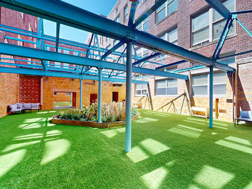 A green lawn with a blue metal frame structure above it.
