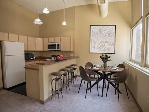 A kitchen with a table and chairs.
