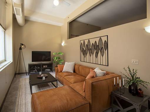 A living room with a brown couch and a black coffee table.