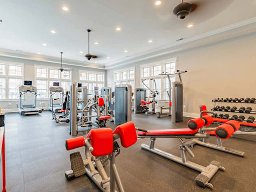 A gym with a variety of equipment including weights and machines.