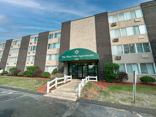 an apartment building with a green awning and stairs in front of it