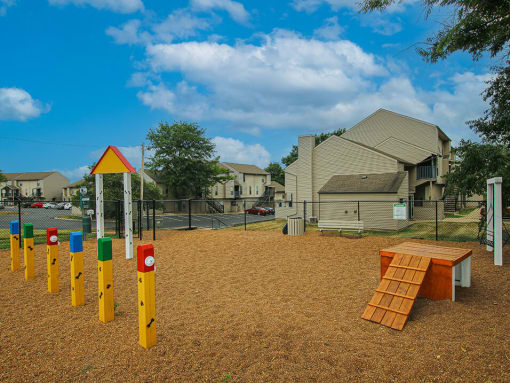 a playground with a picnic table in the foreground and houses in the background