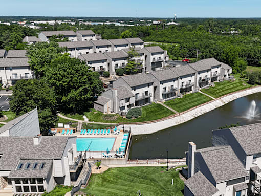 A large building complex with a pool and a fountain.