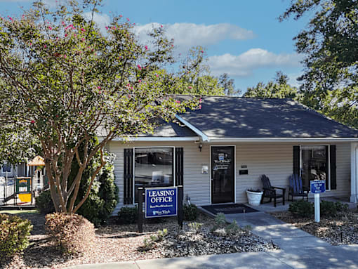 A leasing office sign is displayed in front of a small building.