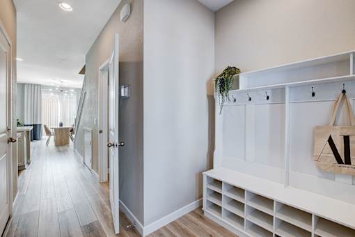 A hallway with a white bench and a bag hanging on it.at Copper Creek Apartments, Nevada
