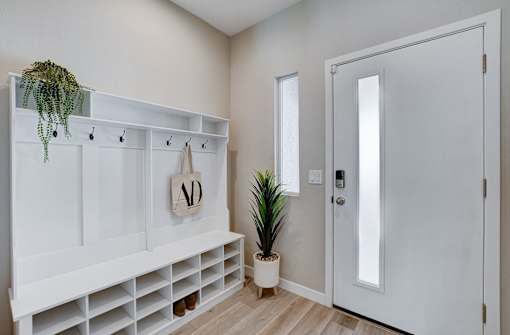A white entryway with a coat rack and a potted plant.at Copper Creek Apartments, Las Vegas Nevada