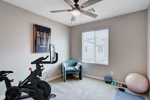 A room with a stationary bike, a chair, and a ball.at Copper Creek Apartments, Las Vegas, 89123