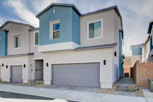 A modern two-story house with a garage door.at Copper Creek Apartments, Las Vegas, NV