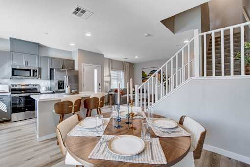 A modern kitchen with a dining table set at Copper Creek Apartments, Las Vegas, 89123