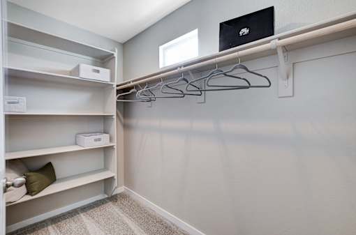 A room with a laptop on a shelf and clothes hangers.at Copper Creek Apartments, Nevada, 89123