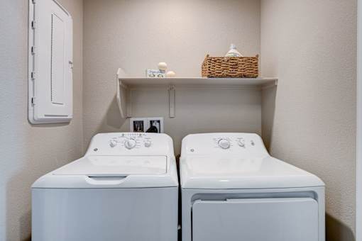 A small laundry room with a washer and dryer.at Copper Creek Apartments, Las Vegas, 89123