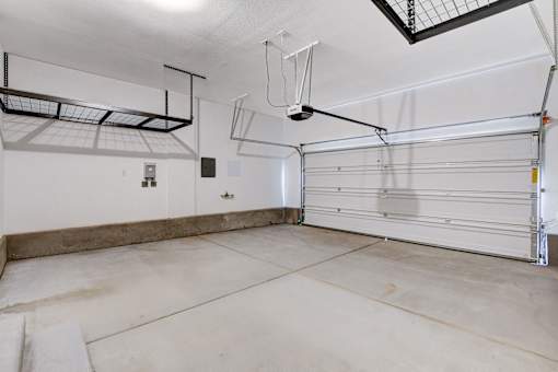 A spacious garage with a white floor and a ceiling fan.at Copper Creek Apartments, Las Vegas, NV 89123