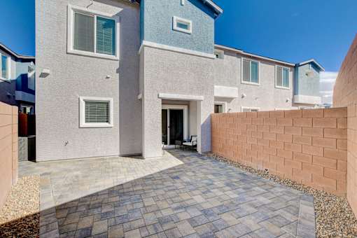 A modern house with a grey and blue exterior and a brick wall.at Copper Creek Apartments, Las Vegas, NV 
