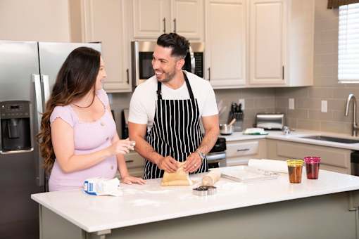 A man and a woman are cooking together in a kitchen.at Copper Creek Apartments, Las Vegas Nevada