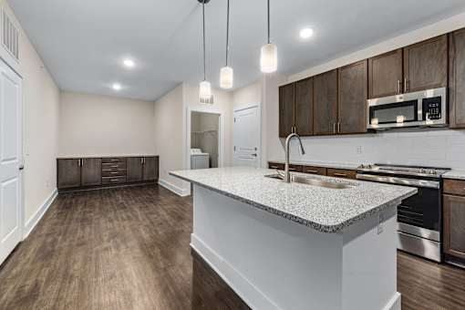 A kitchen with a white countertop and wooden cabinets.