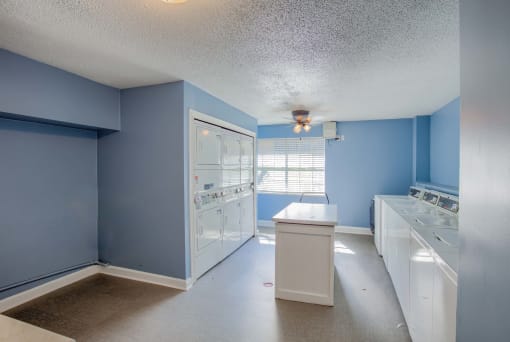 a blue and white kitchen with blue walls and white appliances