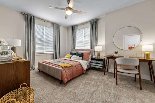 A bedroom with a bed, desk, and chair.