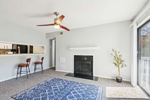A living room with a fireplace and a ceiling fan.