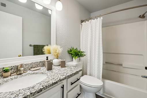 A white bathroom with a sink, toilet, and bathtub.