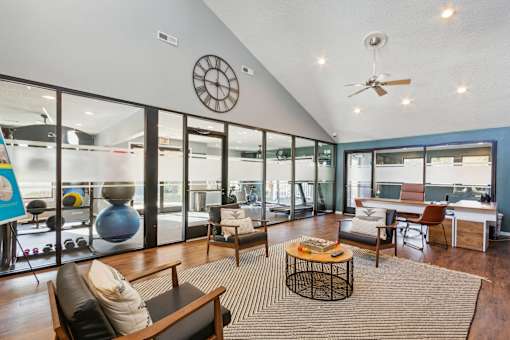 A living room with a large window and a ceiling fan.