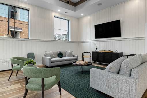 A living room with a grey couch, a green chair, and a white sofa.