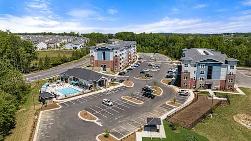 A large building complex with a pool and parking lot.