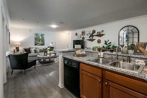 A kitchen with a black dishwasher and a black chair.