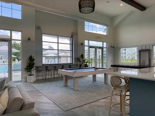 A room with a pool table and a view of a street outside.