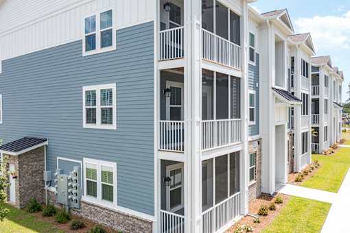 A row of modern townhouses with balconies and garages.