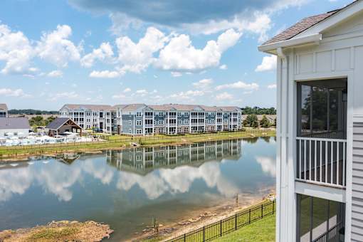 A building with a white exterior is reflected in a body of water.