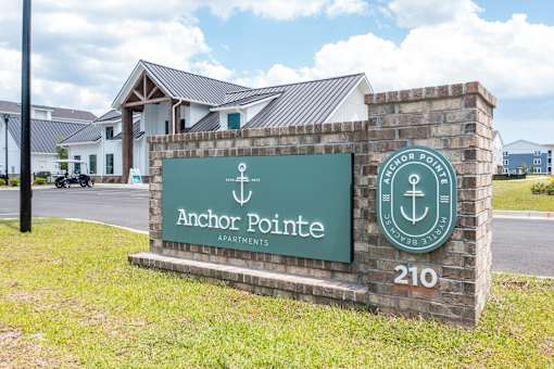 A sign for Anchor Pointe Apartments is displayed in front of a building.