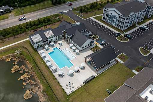 A large building with a pool in the middle of a grassy area.