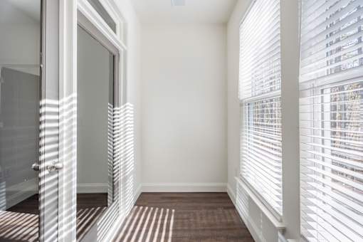 A hallway with white walls and striped carpeting.