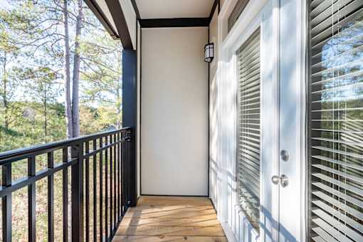 A balcony with a black railing and a white door with a window above it.