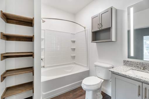 A white toilet sits next to a bathtub in a bathroom.