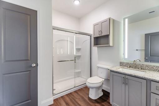 A bathroom with a toilet, sink, and shower.