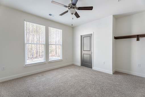 A room with a ceiling fan and a door.