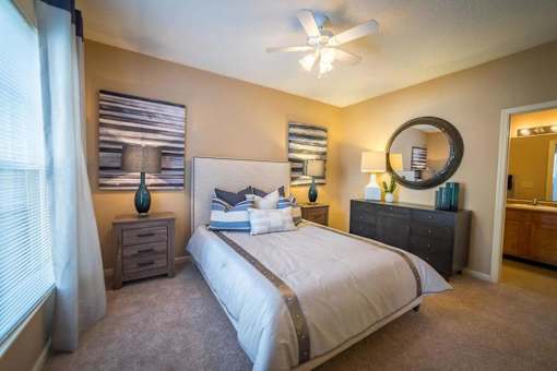 a bedroom with a large bed and a ceiling fan