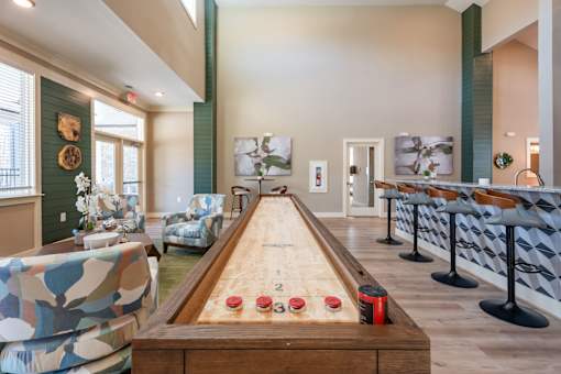 A room with a pool table and chairs.