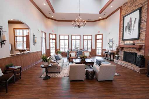 A large, well-lit living room with a fireplace and a chandelier.