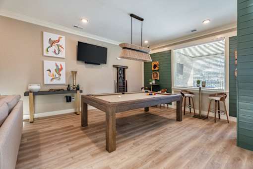 A living room with a wooden floor and a grey sofa.