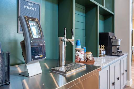 A tap machine is on a counter with a screen and a handle.