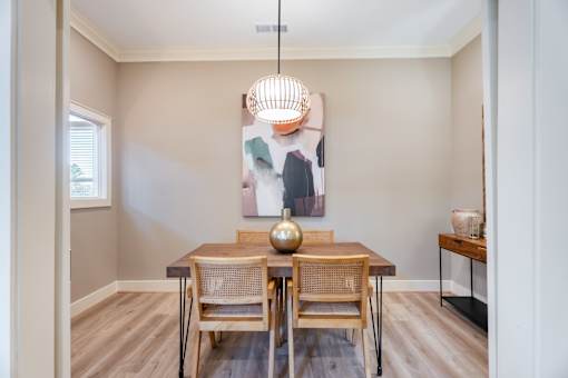 A dining room with a wooden table and chairs.