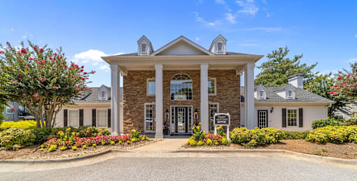 A large clubhouse with a front yard and a driveway at Heights at New Garden apartments in Greensboro, NC.