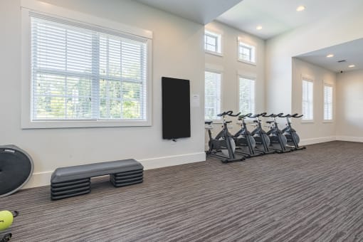 a fitness room with exercise machines and a large window