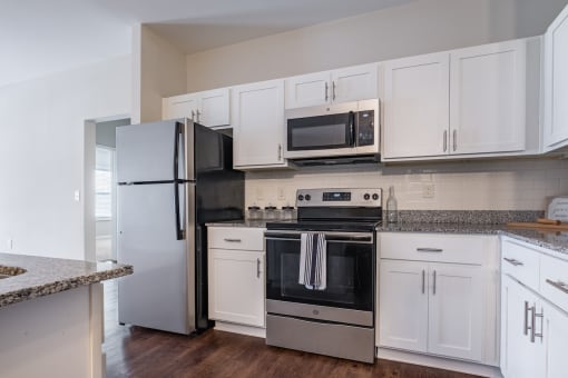 a kitchen with white cabinets and stainless steel appliances