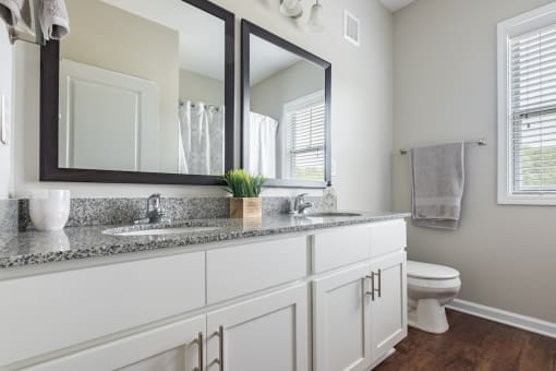 a bathroom with two mirrors and a sink and a toilet