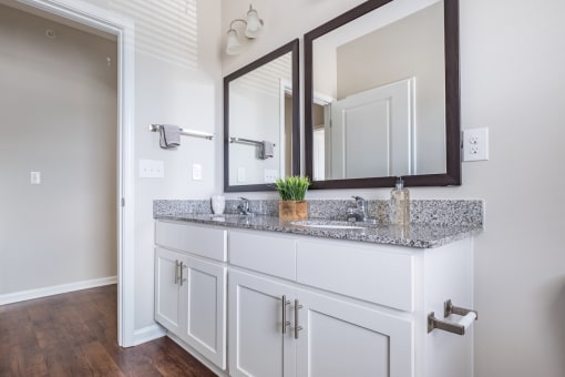 a bathroom with a vanity with two mirrors and a sink