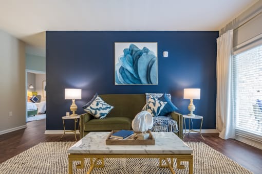 a living room with blue accent wall and a green couch