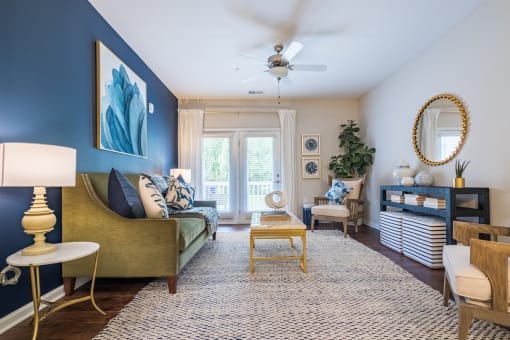 a living room with blue walls and a ceiling fan